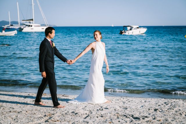 Les mariés main dans la main au bord de l'eau, plage privée de Brégançon
