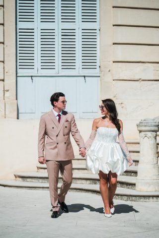 Balade romantique des mariés main dans la main sous le soleil du Sud après leur union civile.