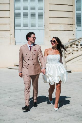 Un couple au style urbain chic avec lunettes de soleil se sourit sur le parvis de la mairie marseillaise.
