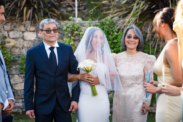 Arrivée émouvante de la mariée au bras de ses parents sous le regard des invités en Provence.