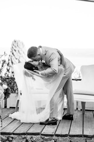 Baiser romantique à la fin de l'office immortalisé en noir et blanc par le photographe de mariage.