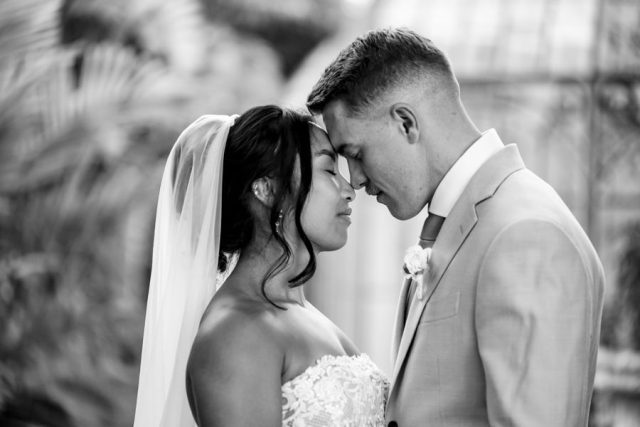 Magnifique portrait de profil du couple en noir et blanc, mettant en valeur le voile de la mariée.