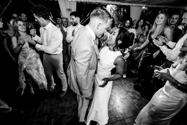 Les mariés dansent et chantent avec leurs invités, capturés en noir et blanc par Gilles Perbal.