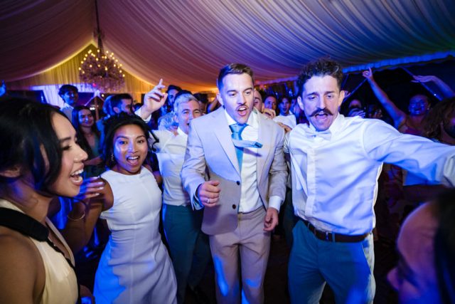 Invités s'amusant sur la piste de danse sous les éclairages de la soirée de réception.