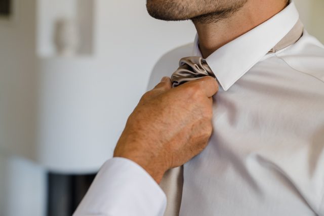 Le marié ajuste sa cravate lors de ses préparatifs de mariage dans le Var.