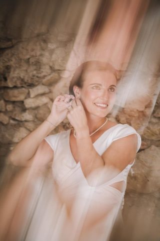 Portrait lumineux de la mariée souriante pendant ses préparatifs de mariage.