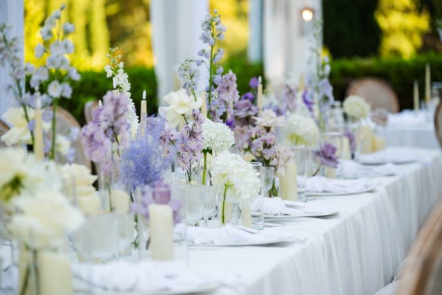 Décoration florale de table de mariage aux tons pastel sous les arbres de la Bastide des Adrets.