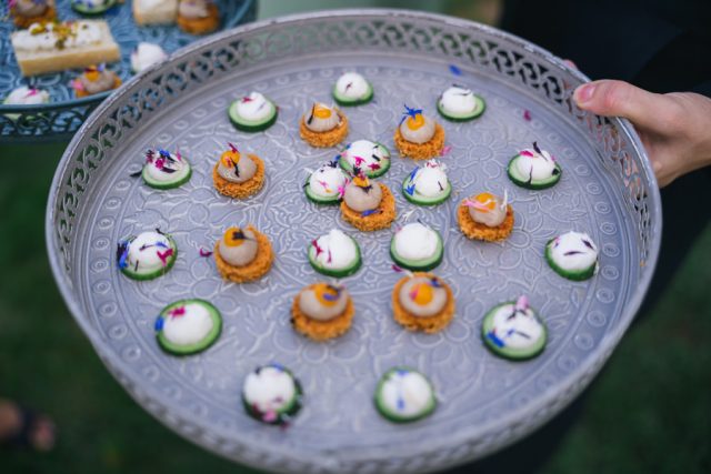 Présentation soignée des canapés salés sur un plateau argenté pendant le cocktail.