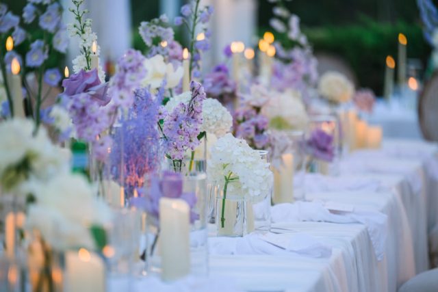 Ambiance tamisée avec des bougies sur les tables du dîner de mariage au crépuscule.