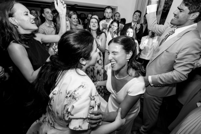 La mariée danse joyeusement au cœur de la fête en noir et blanc.
