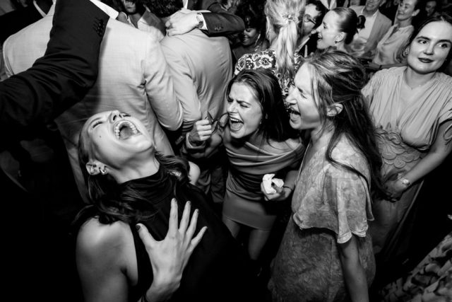Les invités s'amusent intensément pendant la soirée dansante du mariage (Noir et blanc).
