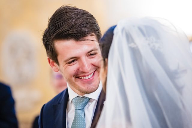 Le marié adresse un sourire ému à sa future femme devant l'autel.