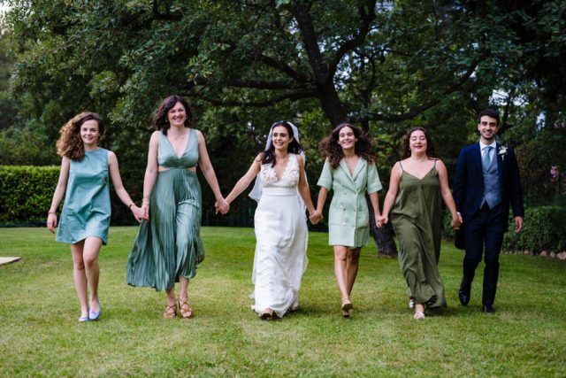 La mariée marche en se tenant par la main avec ses demoiselles d'honneur en robes vertes.
