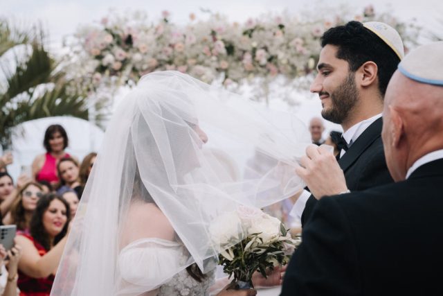 Le marié pose le voile sur le visage de la mariée lors de l'émouvante cérémonie du Bedeken.