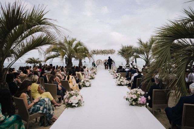 Vue globale de l'allée centrale menant à l'arche nuptiale dressée face à la mer en Italie.