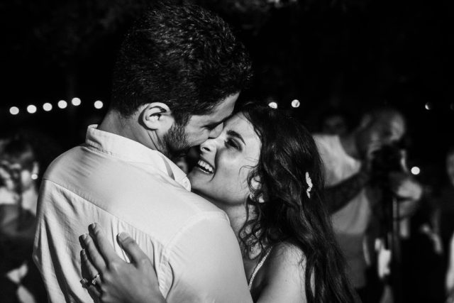 Baiser du couple entouré de leurs proches faisant la fête (Noir et blanc capturé par Gilles Perbal).