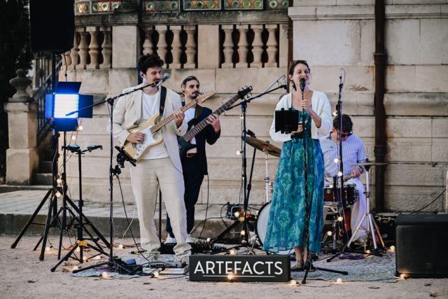 Groupe de musique live animant le cocktail de mariage dans les jardins du domaine.