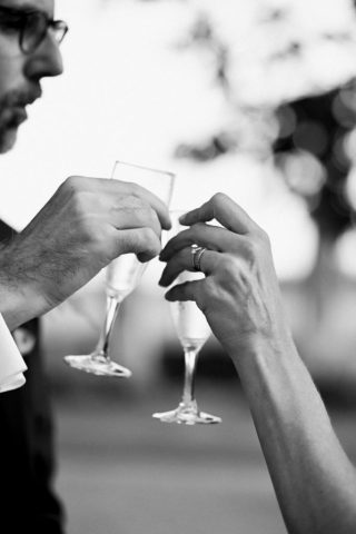 Les mariés trinquent avec leurs coupes de champagne pendant la réception (Noir et Blanc).