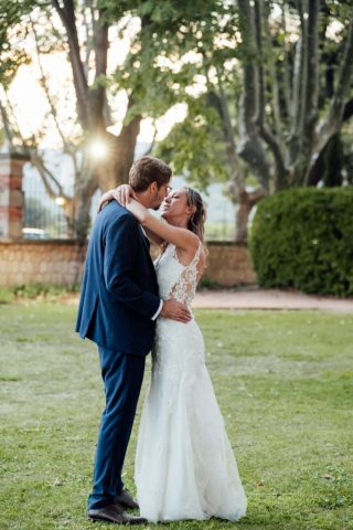 Le couple s'enlace lors de leur séance photo de mariage sur les grandes pelouses de la propriété.