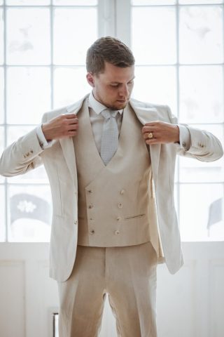 Le marié ajuste élégamment son costume avant la cérémonie de mariage.