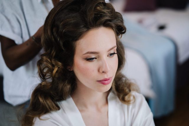 Portrait de la mariée lors de sa mise en beauté et de son maquillage le jour J.