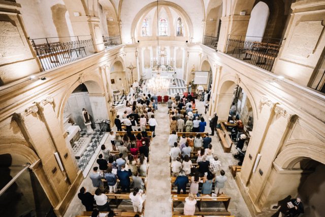 Vue en plongée spectaculaire de la nef de l'église pendant la messe de mariage.