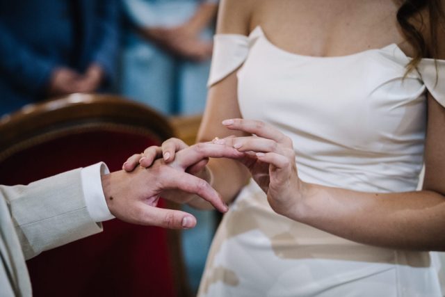 Le marié glisse l'alliance au doigt de la mariée lors de la cérémonie religieuse.