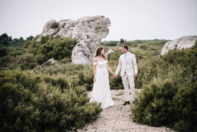 Le couple pose au milieu de la végétation méditerranéenne lors de leur journée de mariage.