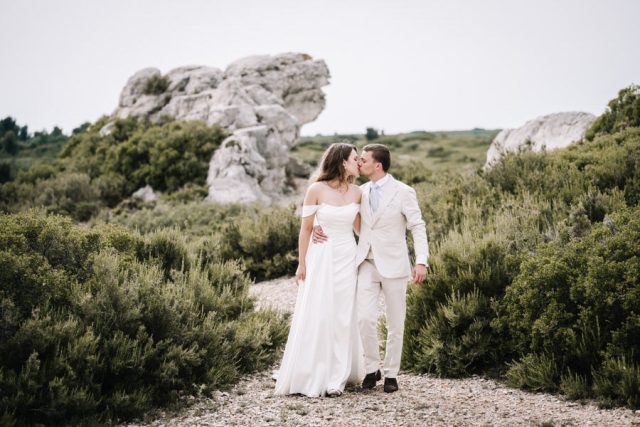 Promenade romantique des jeunes mariés main dans la main en Provence.
