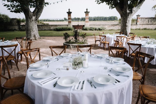 Mise en place des tables rondes pour le dîner de réception en extérieur au domaine.
