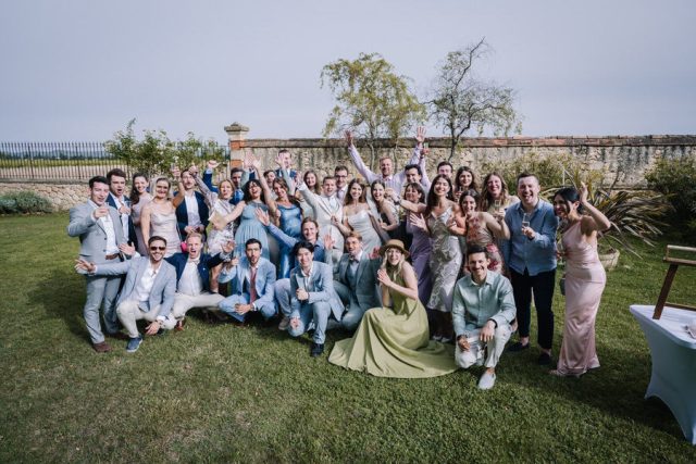 Photo de groupe décontractée et amusante avec les amis des mariés dans les jardins.