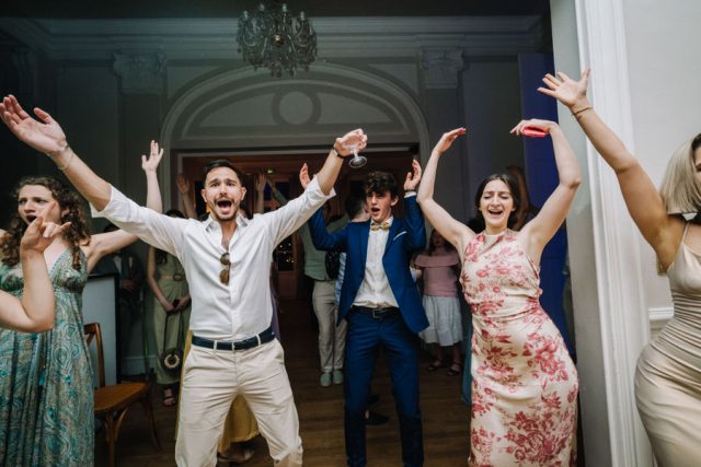 Les invités font la fête sur le dancefloor de la salle de réception illuminée.