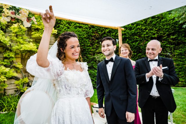Moment de joie et de rires partagés par les mariés et l'officiant sous la Houppa à Antibes.