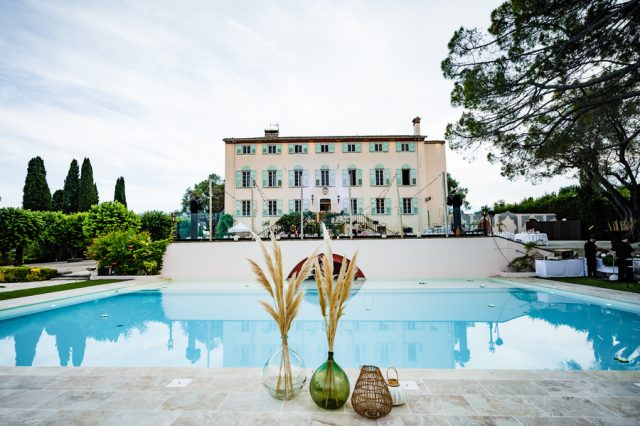 Vue majestueuse sur la grande piscine et la façade historique de la Bastide du Roy à Antibes.