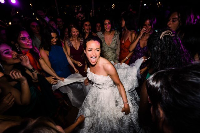 La mariée danse avec une énergie débordante au milieu de ses invités lors de la soirée festive.
