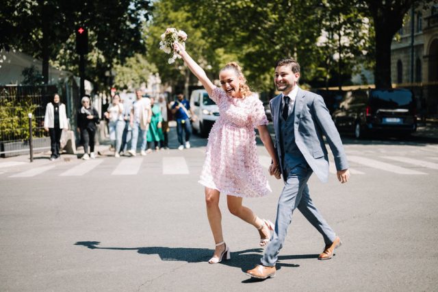 Le couple traverse joyeusement une rue de Paris après leur union à la mairie du 6ème.