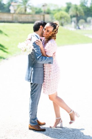 Les mariés s'embrassent tendrement lors de leur séance photo de couple au Jardin du Luxembourg à Paris.